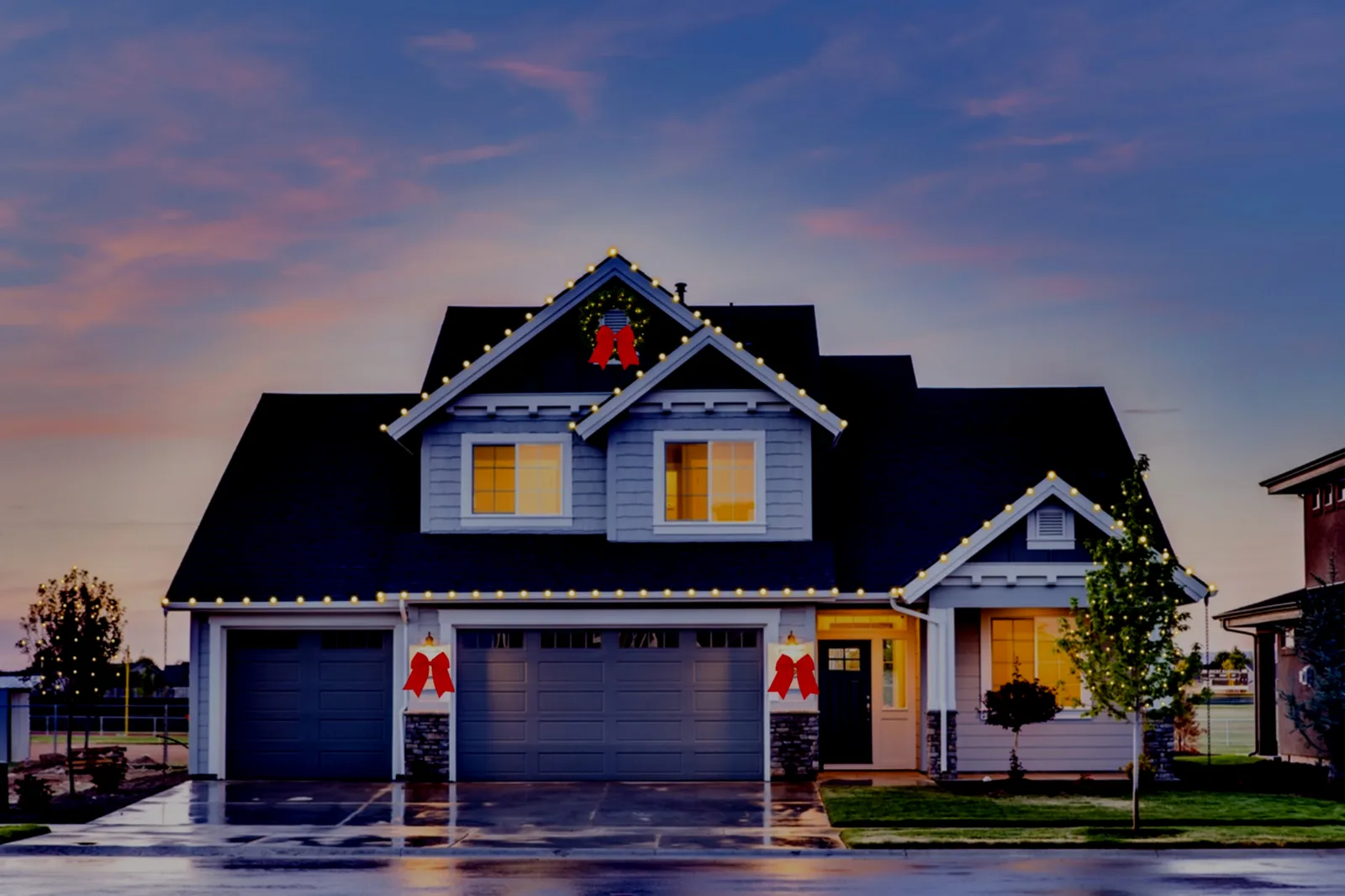 The same house with warm-white roofline lights, a wreath, and red bows designed in Strandr